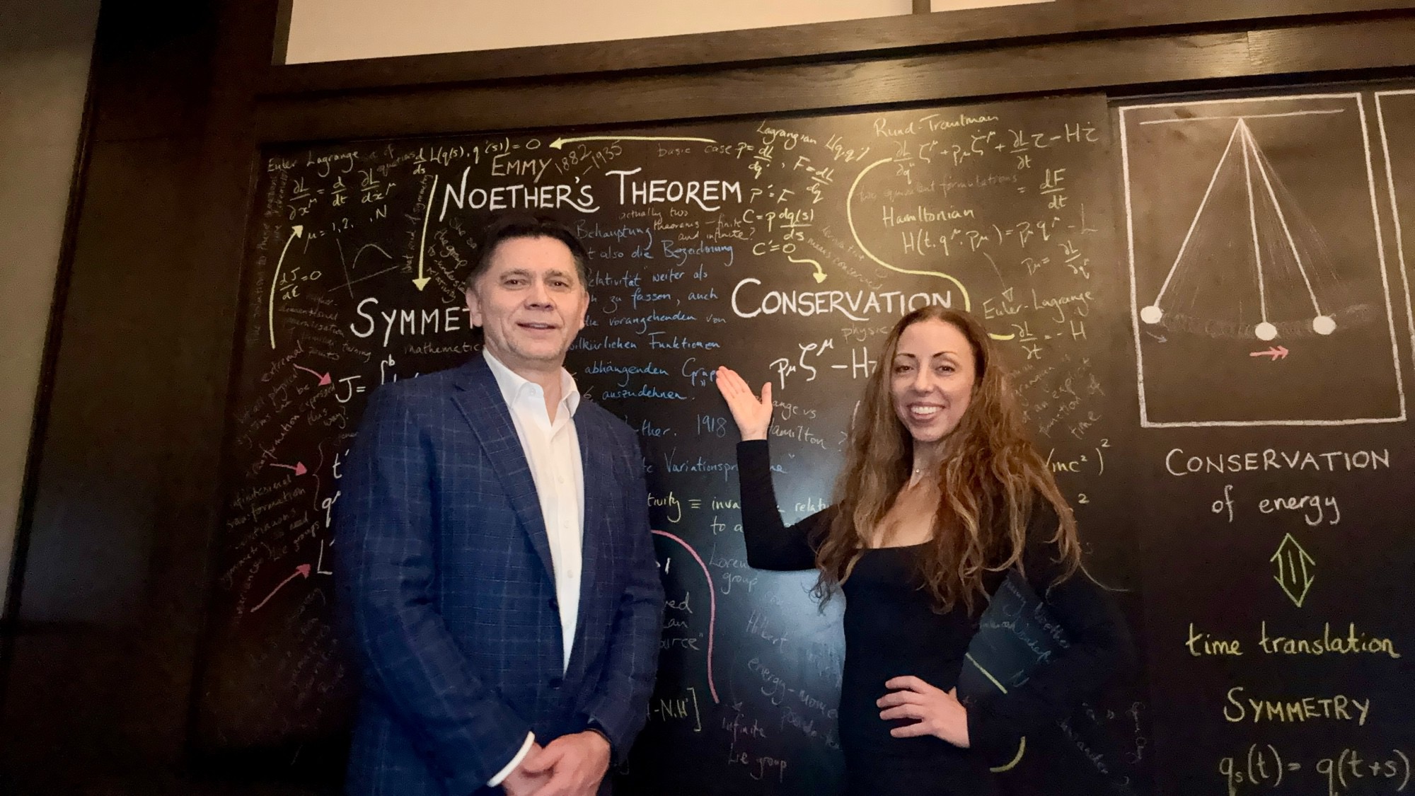 Dr. Skeens and Dr. Pastouk in discussion at a blackboard